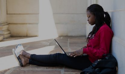student working on a laptop outside